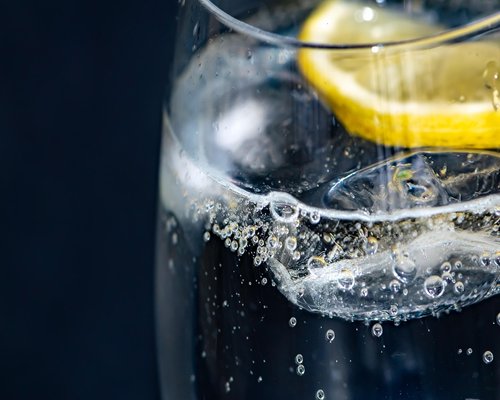 glass of fresh water with lemon slices on a bright table