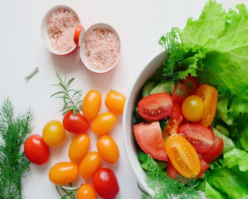 healthy fresh salad with tomatoes and greens in a bowl
